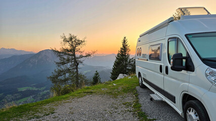 Awake to the soft light of dawn illuminating the majestic mountains surrounding Hallstatt, Austria. Relaxing from a cozy camper van, the landscape unfolds with stunning natural beauty at sunsrise