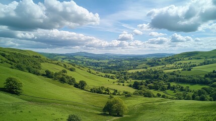 Obraz premium Breathtaking Panoramic View of Lush Green Hills Under a Bright Blue Sky with Fluffy White Clouds in a Serene Countryside Landscape