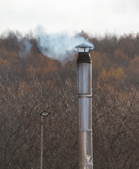 A tall chimney with smoke coming out of it