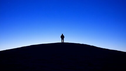Solitary Figure Stands on Hilltop Under Night Sky