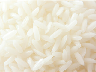 Close-up view of grains of rice scattered on a clean white surface, highlighting their texture and color.