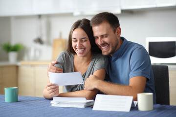 Happy couple checking bills at home