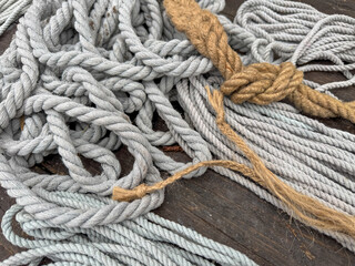 A bunch of different colored strings are tangled together on a wooden surface