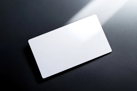 Blank white card on dark background with soft light and shadow