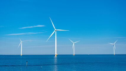 Windmill turbines generating electric green energy with a blue sky green energy concept in the Netherlands, energy transition in Europe