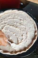 making pizza spreading souse cheese white garlic
