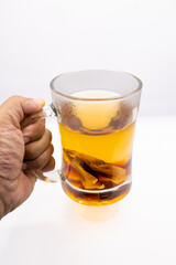 This inviting image shows a hand gently holding a glass mug of steaming hot tea, capturing the essence of comfort and warmth. 