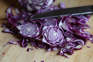 chopped red cabbage and a knife on wooden board