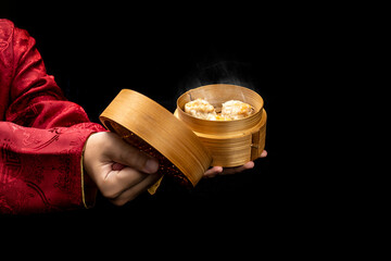 Chinese person showing dim sum dumpling on bamboo wooden basket bowl