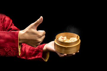 Chinese person showing dim sum dumpling on bamboo wooden basket bowl