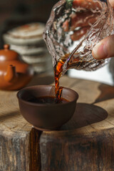 Pouring a soothing cup of tea into a beautifully crafted ceramic cup with an elegant setup