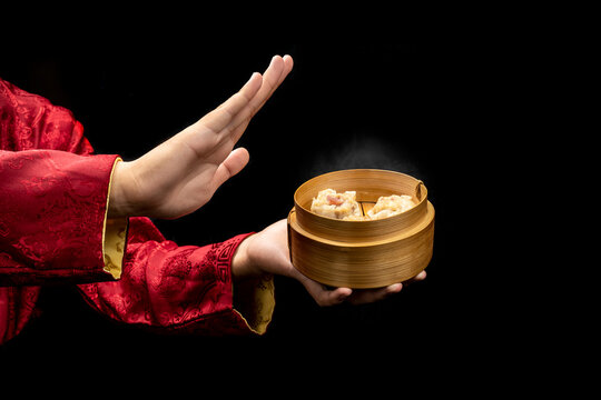 Chinese person showing dim sum dumpling on bamboo wooden basket bowl