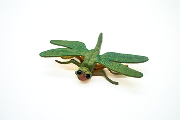 Obraz premium Green dragonfly toy isolated on white background, showcasing detailed wings and body texture. Perfect for educational purposes or insect themed decorations