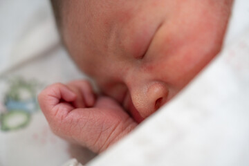 Newborn baby peacefully sleeping with small feet and adorable face