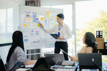 The boss stands near the board with graphs, demonstrates statistics, various personnel attending the training,