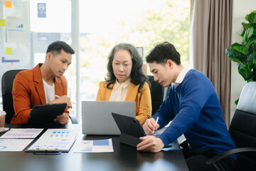 Group of young Asian business people discussing business plan at modern startup
