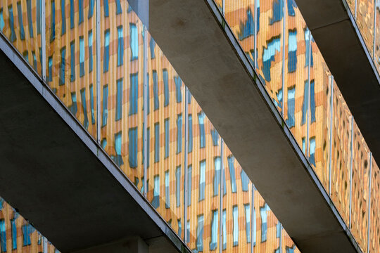 This image features abstract layers of architecture against a backdrop, showcasing the interplay of structural elements and reflections capturing urban dynamics in Amstedam