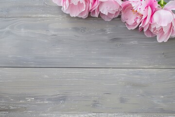 A delicate bouquet of pink peonies lying on a textured light gray surface, perfect for spring and romantic settings.