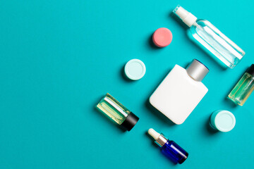 Cosmetics SPA branding mock-up, top view with copy space. set of tubes and jars of cream flat lay on colored background