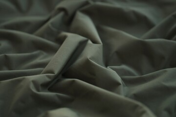 Texture of Dark green military uniform textile cloth with folds