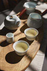 An Elegant Tea Set Displayed on a Gorgeous Wooden Tray Accentuated by Soft Shadows