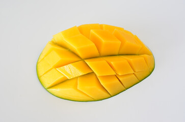 a yellow mango fruit that is cut in half and sliced 