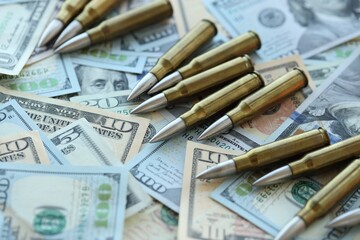 Yellow cartridges and bullets on dollar bills
