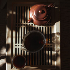 An Elegant Tea Set arranged beautifully on a Wooden Tray, enhanced by Natural Light