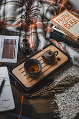 A Comfortable and Inviting Tea Setup Accompanied by Books and a Soft, Warm Blanket