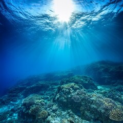 Obraz premium A stunning underwater scene with blue sunlight piercing the deep-sea abyss, creating tranquil patterns, ideal for marine-themed or nature-inspired visuals