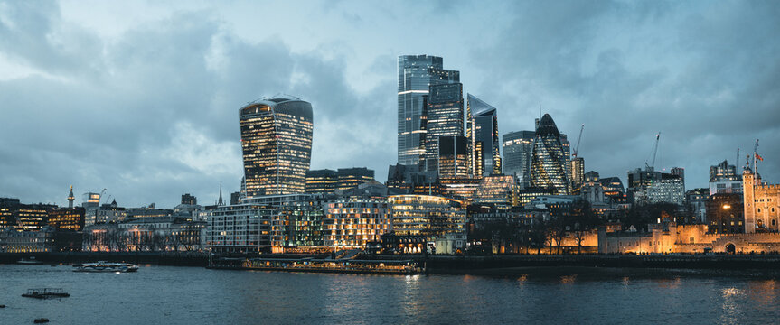 London skyline illuminating at dusk with tower of london and river thames