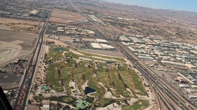 Footage through the front of a helicopter as it flies over the south end of the Las Vegas Strip then the golf course and over the airport