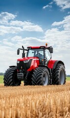 Obraz premium Red Agricultural Tractor Working in a Golden Wheat Field Under a Bright Blue Sky with White Clouds