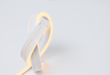 Flexible warm white led tape glowing on white background.