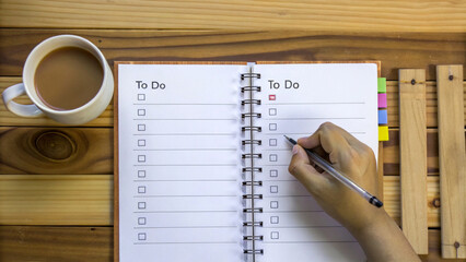 Person creates to do list, prioritizing tasks with systematic order and planning
