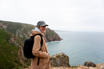 Happy and smiling woman contemplating the panoramic views of the cliffs.