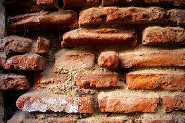 Old red brick wall with weathered texture and visible mortar, perfect for backgrounds or architectural studies