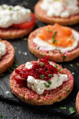 Lentil and pea protein veggie crispy cakes with cottage cheese, beetroot, tomatoes, radishes, cucumber and salmon