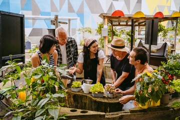 Urban gardening class with a diverse group of people gathered around a raised garden bed.