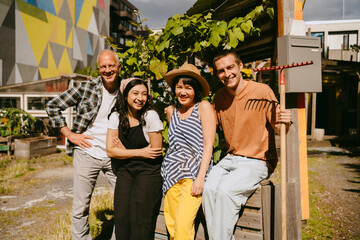 A group of people socializing and gardening together outdoors on a sunny day.