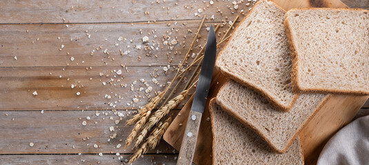 Healthy wholemeal bread slices on wooden table. Panorama view