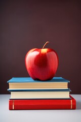 Red apple on a stack of books against a moody backdrop