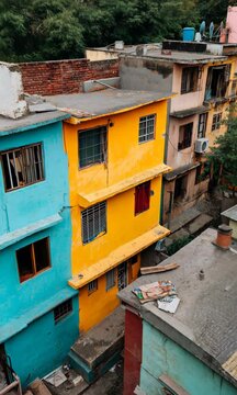 A row of colorful buildings with a yellow one in the middle. The buildings are in a city setting