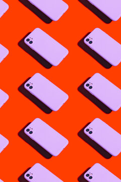 Violet smartphones on an orange background form a repeating pattern.
