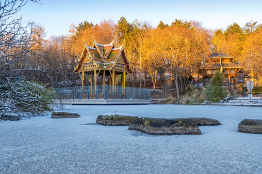 Snowy Japanese garden and Thai Sala with Buddha statue in Munich's Westpark during winter