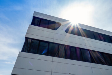 Modern sustainable office building in Augsburg, Germany with sunlight and lens flare
