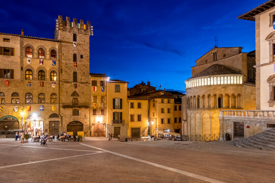 Piazza Grande with church of Santa Maria Della Pieve and palace Lay Fraternity at dusk under blue sky in Arezzo, Tuscany, Italy