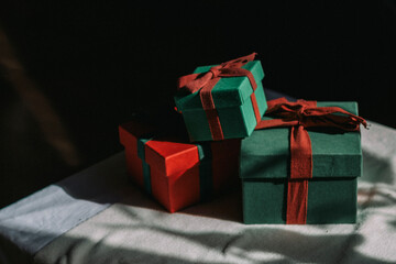 A mountain of gifts stands on a table with a white tablecloth. Contrast photography. Preparing gifts