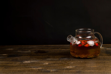 red rosehip fruits on a black tea table