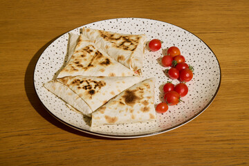 Enjoy delicious grilled wraps filled with juicy cherry tomatoes on a spotty plate
